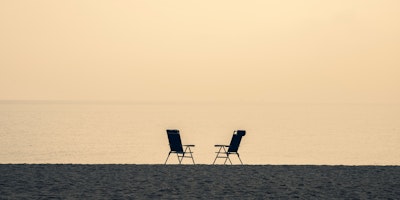 Two deck chairs on a beach