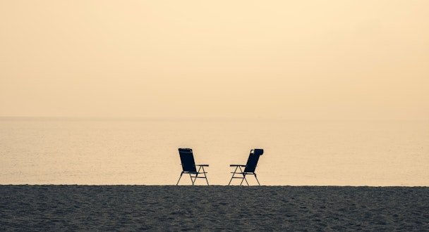 Two deck chairs on a beach