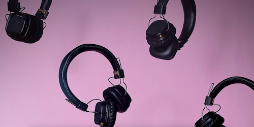 Headphones falling against a purple background representing the different forms of audio content