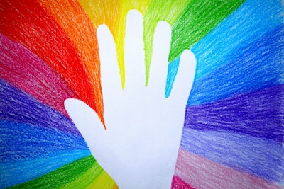 The blank outline of a hand against a crayon-drawn rainbow background