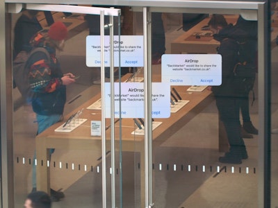 AirDrop messages promoting BackMarket, superimposed on top of an image of customers in an Apple Store