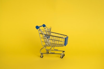 A trolley against a yellow background (representing retail media)