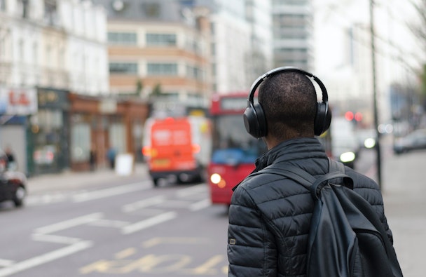 Photograph of a man on a UK street wearing headphones