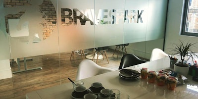 Photograph of an office space with a frosted glass divider showing the Brave Spark logo