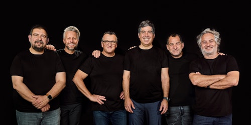 Gut and Globant's executive teams, standing in front of a black background wearing black T shirts