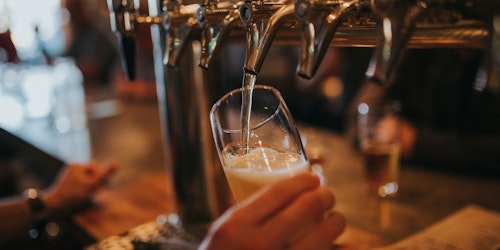A pint of beer being poured from a tap