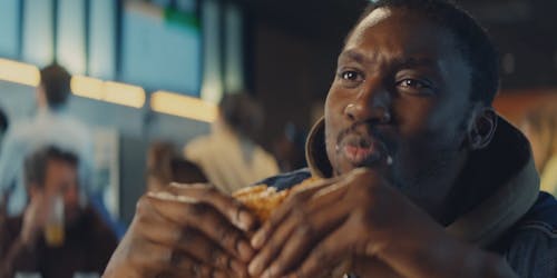 A man eating a Burger King whopper in a restaurant A man eating a Burger King whopper in a restaurant
