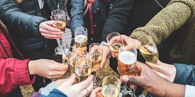 A group of people join glasses for a toast