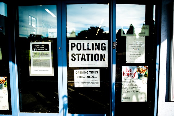 A stock photo showing a sign hung on a glass door showing a temporary polling station in the UK