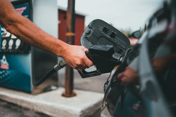 A person fills up a car with petrol A person fills up a car with petrol