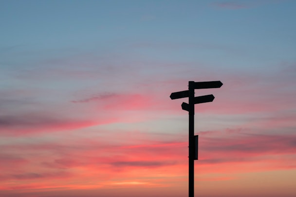 A signpost sillhouetted against an evening sky