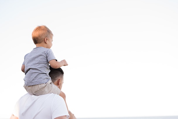 a child sitting on its parent's shoulders