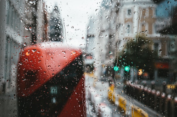 A London bus seen in front of raindrops on a window, on a winter's day
