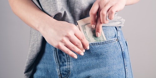 A person pulls a fistful of dollars from their pocket