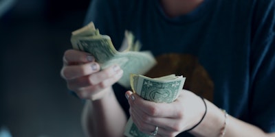 woman counting dollar bills