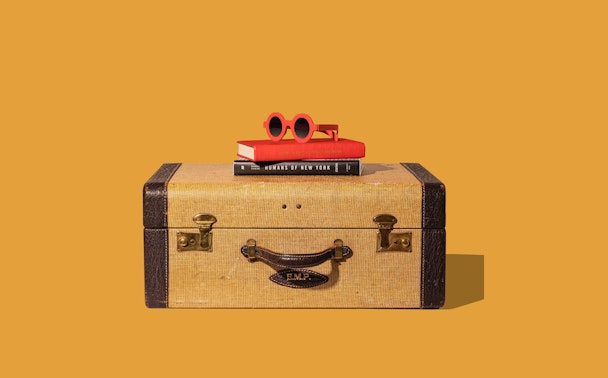 Vacation suitcase on orange background
