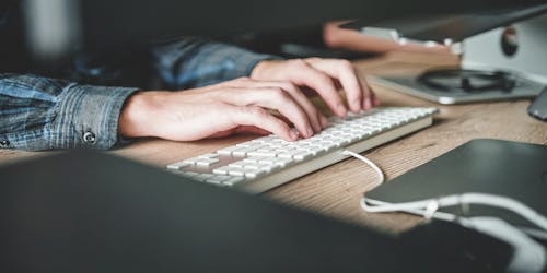 A person typing on a keyboard A person typing on a keyboard