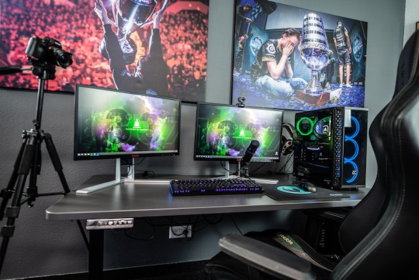 A gaming setup, with esports posters and multiple screens plus streaming equipment