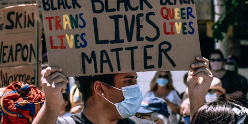 Man at protest holds Black Lives Matter placard