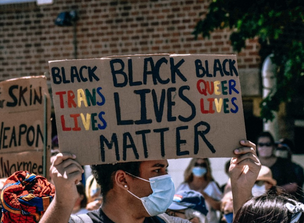 Man at protest holds Black Lives Matter placard