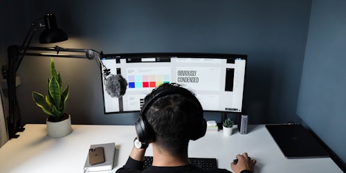 graphic designer sitting at desk wearing headphones