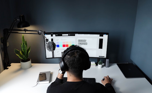 graphic designer sitting at desk wearing headphones