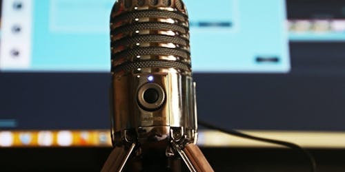 Microphone with computer screen in the background Microphone with computer screen in the background