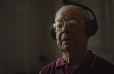 an older man listening to music on headphones