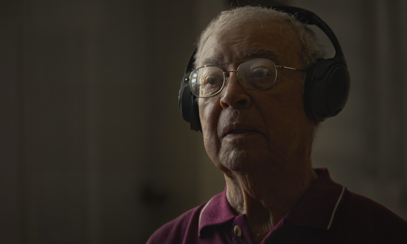 an older man listening to music on headphones