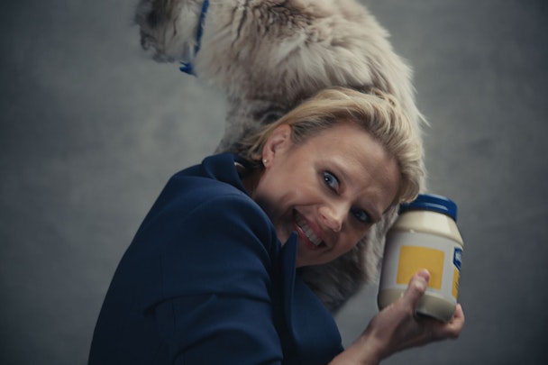 Kate McKinnon with a cat on her shoulder and a jar of mayonaise in her hand