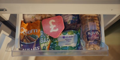 An open freezer drawer showing food inside with a large, red, physical pound-sign roundel sat on top