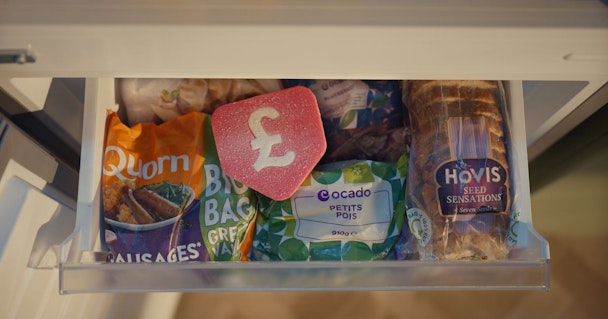 An open freezer drawer showing food inside with a large, red, physical pound-sign roundel sat on top