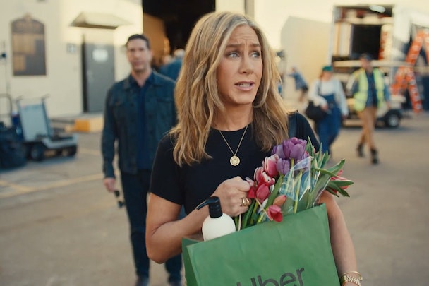 Jennifer Aniston walks away from David Schwimmer, carrying an Uber Eats bag full of flowers