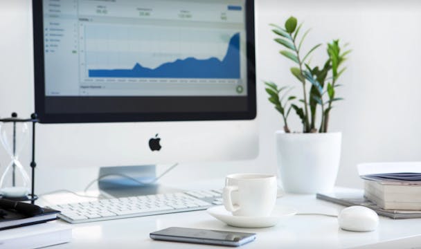 A desk top scene featuring a computer, mobile phone and cup of tea. A desk top scene featuring a computer, mobile phone and cup of tea.