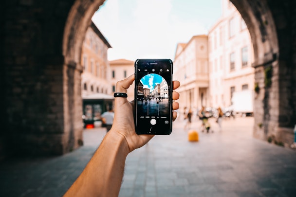 A smartphone capturing an image of an ornate arch.