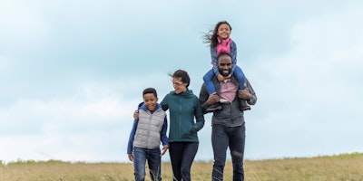 Simplyhealth promotional shot of a family taking a walk outside.