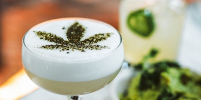 A cocktail with a green cannabis insignia sprinkled on top.