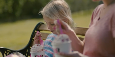 Little girl eating Baskin Robbins ice cream in a cup