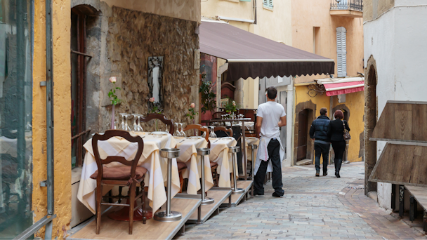 Outdoor seating at a cafe in an alleyway in Cannes, France