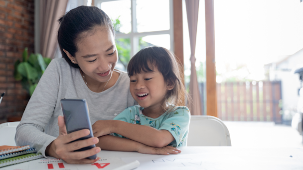 Child with mother looking at phone