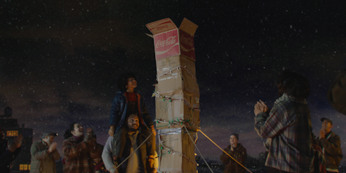 People building makeshift chimney out of cardboard boxes on rooftop
