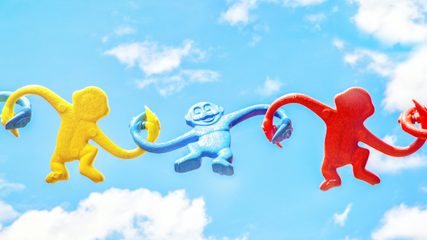 Colorful plastic monkey figurines holding hands