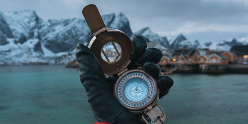 Hand holding compass in cold environment