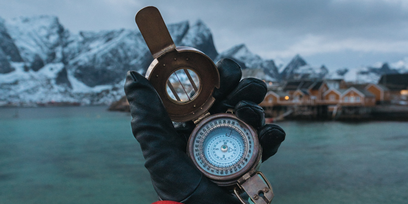 Hand holding compass in cold environment