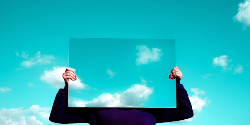 Person holding mirror up to sky
