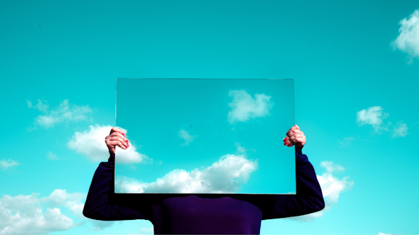 Person holding mirror up to sky