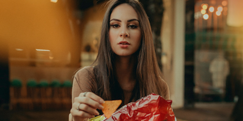 Woman holding bag of Doritos
