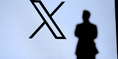 X app logo with man's shadow in front of it
