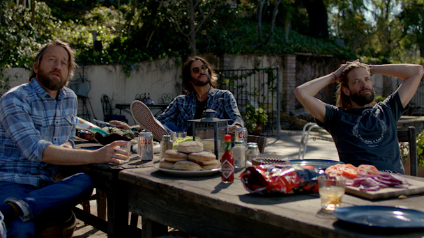 Foo Fighters sitting at a table with Coors beer cans on the table