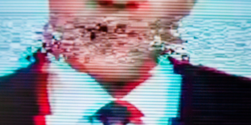 TV glitching while man in suit is talking